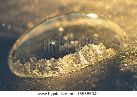 Frozen soap bubble. Cold winter liquid ball experiment. Freezing water with icy patter texture