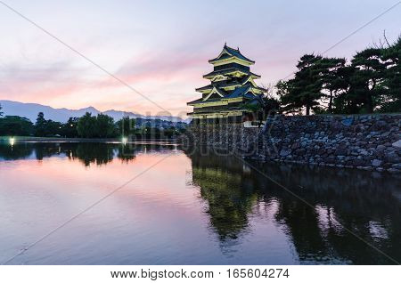 Matsumoto castle and sunset sky reflect on water at nagano japan