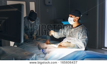 doctor and an assistant in the operating room for surgical venous vascular surgery clinic