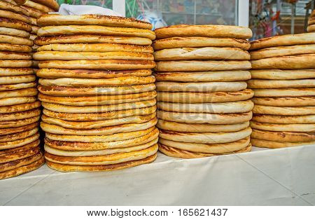 The stacks of the toasted lochira flat breads in the rustic food market of Pungan Uzbekistan.