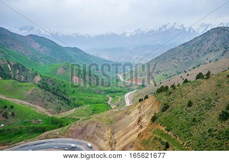 The hard fog rises over the Qurama Mountains in the evening Uzbekistan.
