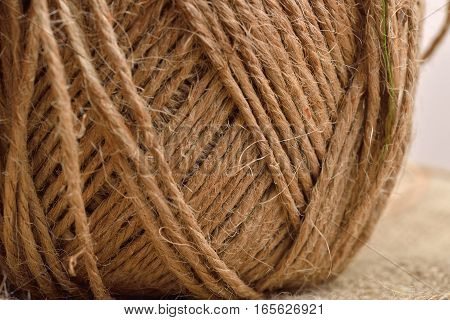 Close up of hank of twine reel of rope ball of hemp thread on jute background
