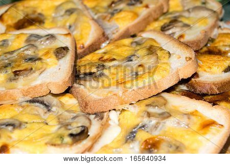 Slices of toasted white bread and seasoned with mushrooms, cheese and egg