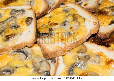 Slices of toasted white bread and seasoned with mushrooms, cheese and egg