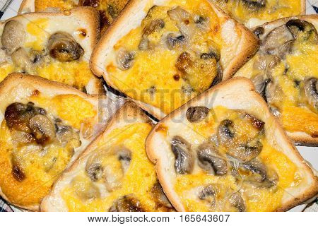 Slices of toasted white bread and seasoned with mushrooms, cheese and egg