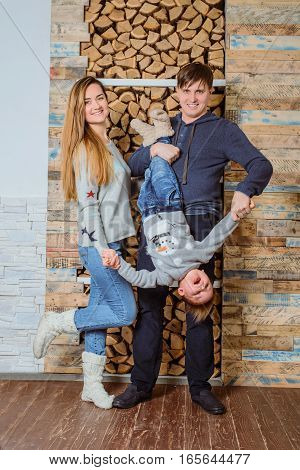 Family playing togather at home, father hold son up side down