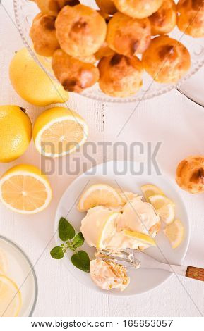 Lemon Profiteroles with custard cream on white dish.