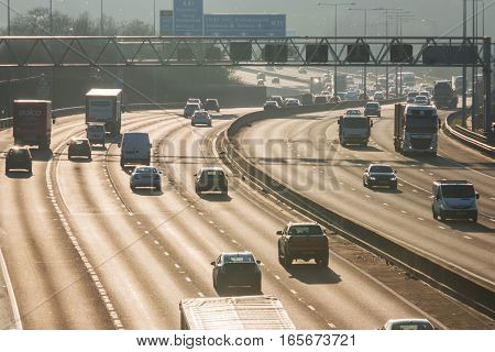 London, UK - January 18, 2017: Busiest British motorway M25 with cars and lorries in a foggy sunset time.