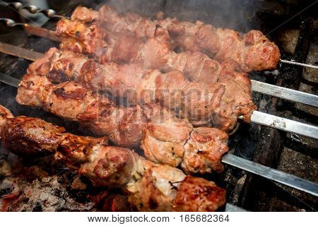 Cooking barbecue dish named shashlyk using skewers on mangal