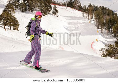 Beautiful beginner snowboarder girl in caucasian mountains