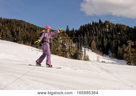 Beautiful beginner snowboarder girl in caucasian mountains