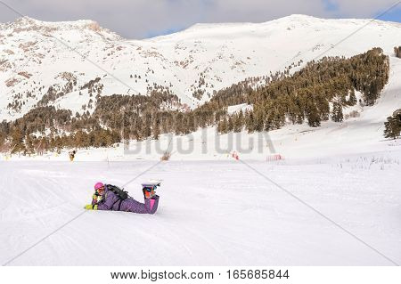 Beautiful beginner snowboarder girl in caucasian mountains