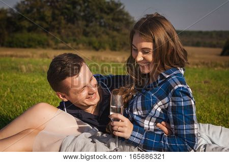 Woman and man having picnic in the field and smiling. happy couple in the sunny day