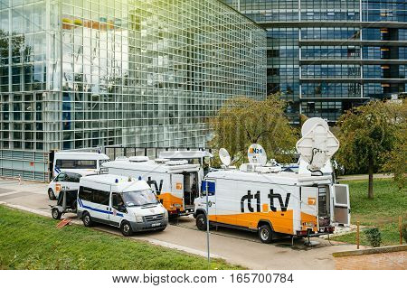 STRASBOURG FRANCE - OCT 7 2015: Tv Television Trucks with multiple Satellite parabolic antennas and fiber optic cables going inside reporting live the official French president visit to the European PArliament in Strasbourg France - everything surveilling