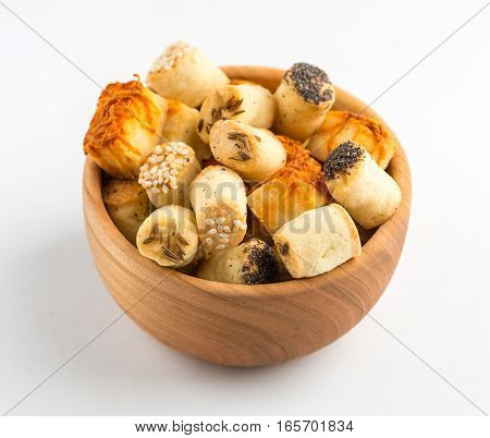 Salty party snacks in wooden bowl. Closeup details.