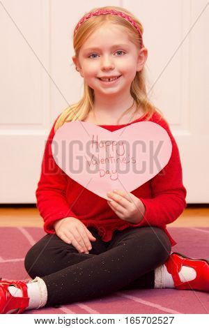 adorable school age girl holding happy Valentine's Day Sign