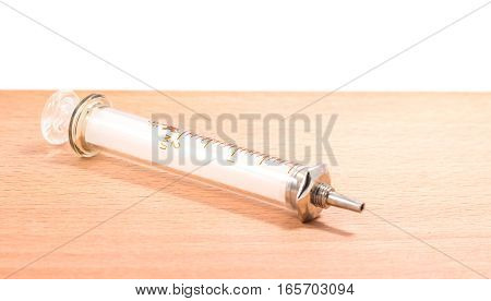 glass insulin syringe on a wooden background on the division syringe for definition of a dose