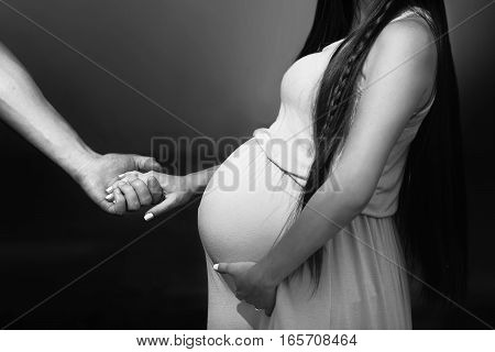 Husband Holding Hand Of Happy Pregnat Woman And Hugging Big Belly Bump. Stylish Family Expecting For