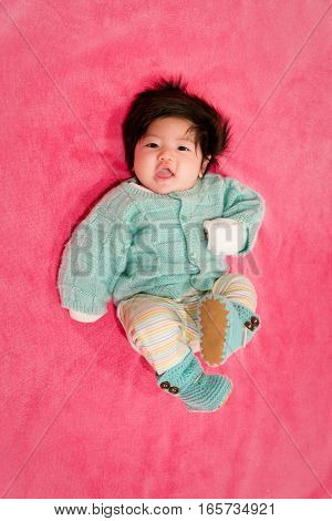 baby girl with cute teal sweater and hot pink background