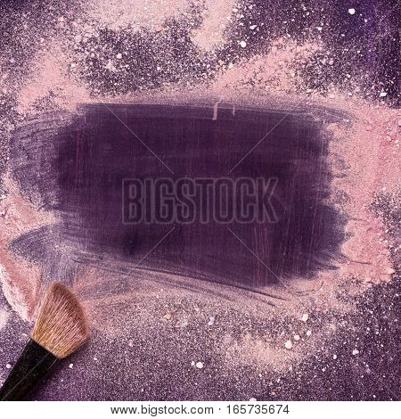 A makeup brush on a purple background, with traces of powder and blush on it forming a frame. A square template for a makeup school business card or flyer design, with plenty of copyspace