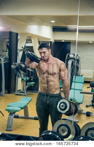 Man training barbell in the gym. At the sports Hall. Man training. Sports. Hard Work. Gym.