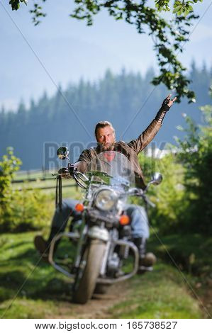 Biker Driving His Cruiser Motorcycle On Road In The Forest