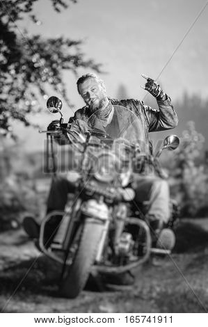Biker Driving His Cruiser Motorcycle On Road In The Forest