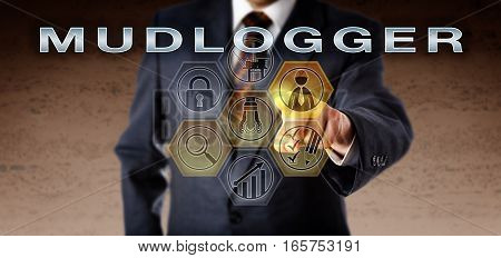 Recruitment manager in blue suit is pressing MUDLOGGER on an interactive remote control monitor. Oil and gas industry job concept for an analytical and evaluative role monitoring petroleum drilling.