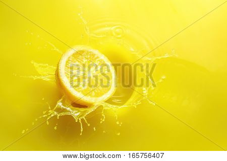 half a lemon splashing in yellow liquid