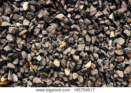 aggregate stone wall - rough gravel consisting of coarse dark gray stones and loose rocks at a stone pit.
