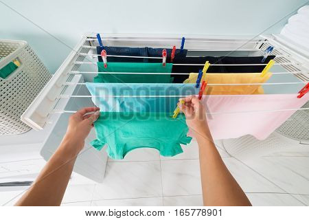High Angle View Of Woman Hanging Wet Clean Cloth On Clothes Line With Clothes Peg