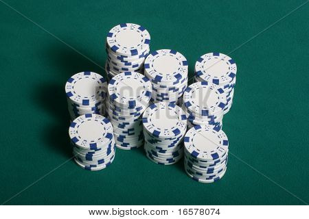 Poker-Chips gestapelt auf einem grünen Filz Pokertisch