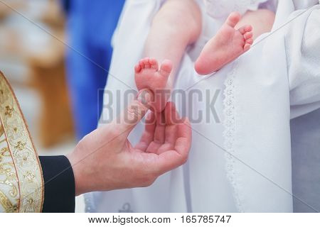 Christening newborn in Orthodox Church. Newborn baby feet
