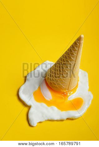Ice cream cone dropped concept with fried egg