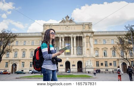 Young Female Tourist With Map And Camera