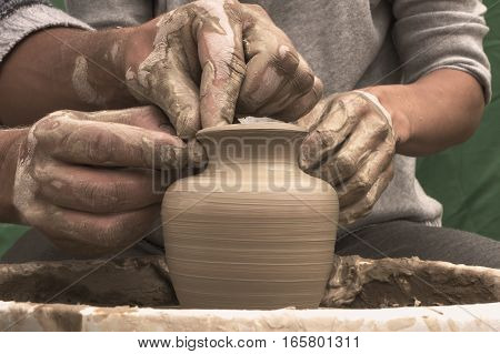 Potter teaches the student the art of clay pottery