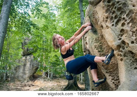 Young Woman Climbing On Large Boulders Outdoor