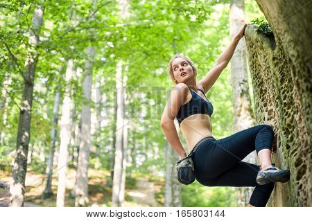 Young Woman Climbing On Large Boulders Outdoor