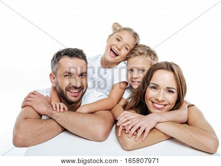 Smiling happy family in white t-shirts hugging