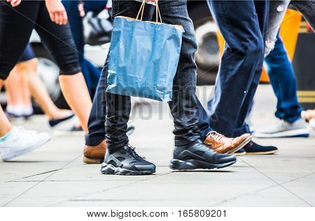 Feet of pedestrians walking on the crosswalk in Oxford street, London. Modern life, travel and shopping concept