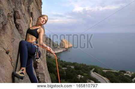 Female Climber Climbing With Rope On A Rocky Wall