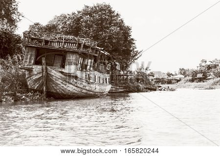 Black and white photo add texture vintage style of the old damaged wooden boat beached on the waterfront for background in Phra Nakhon Si Ayutthaya Province Thailand