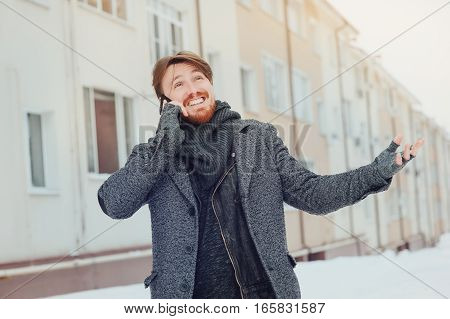 stylish man with a cell phone on the background of the house