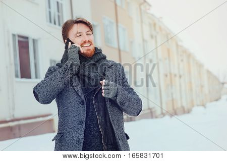 stylish man with a cell phone on the background of the house
