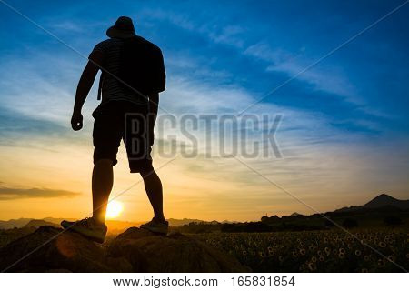 Silhouette of successful traveler look at the sunset