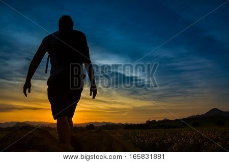 Silhouette of successful traveler look at the sunset