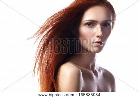 Beautiful ginger young woman with flying hair and naturel makeup. Beauty portrait of sexy model with straight red hair. Long soft shiny hairstyle. Close-up studio shot o fashion look redhead girl