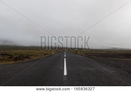 Iceland Road Leading Straight To The Horizon Filled With Clouds. Empty Straight Road Line In Rural I