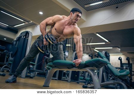 Man training barbell in the gym. At the sports Hall. Man training. Sports. Hard Work. Gym.