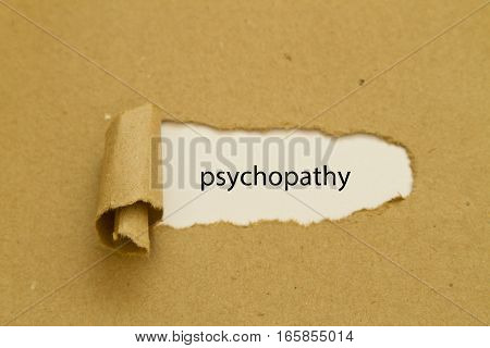 psychopathy word written under torn paper .